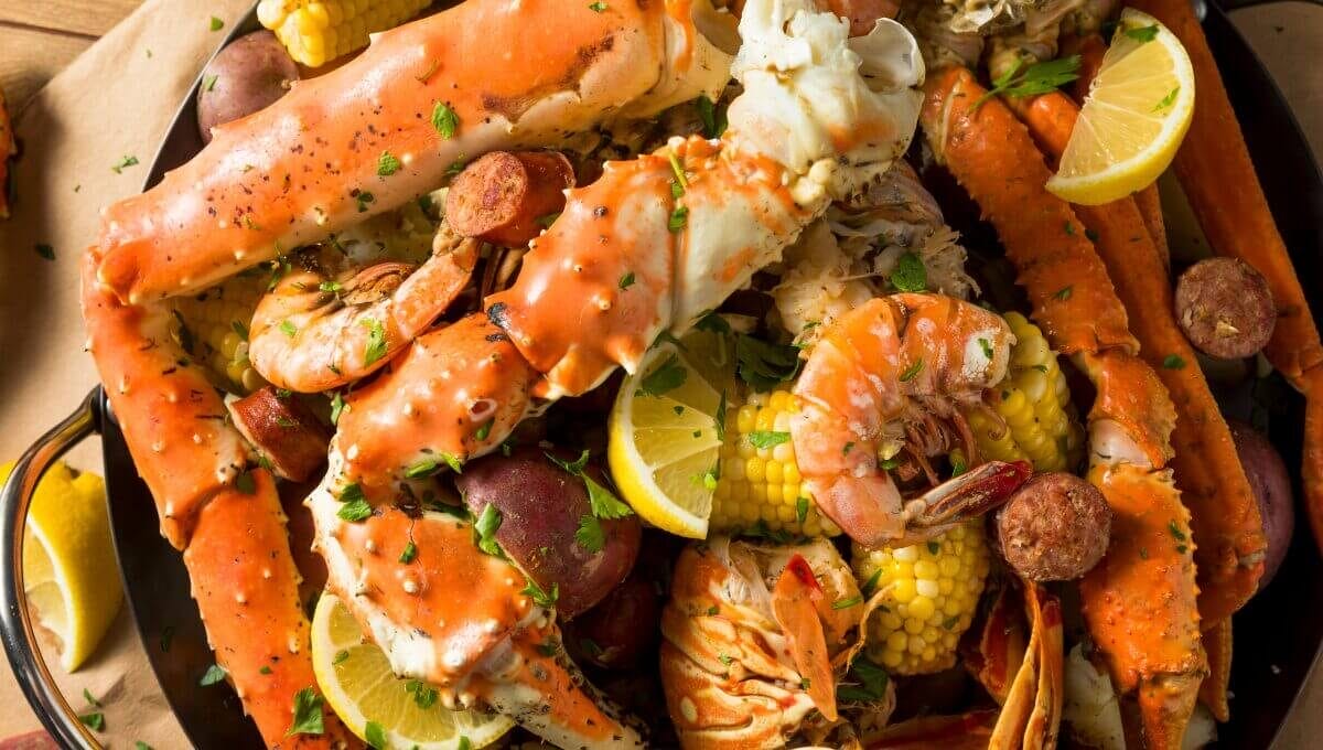 Mélange Cajun servi avec crabes royaux, crevettes, maïs et pommes de terre, garni de persil et citron