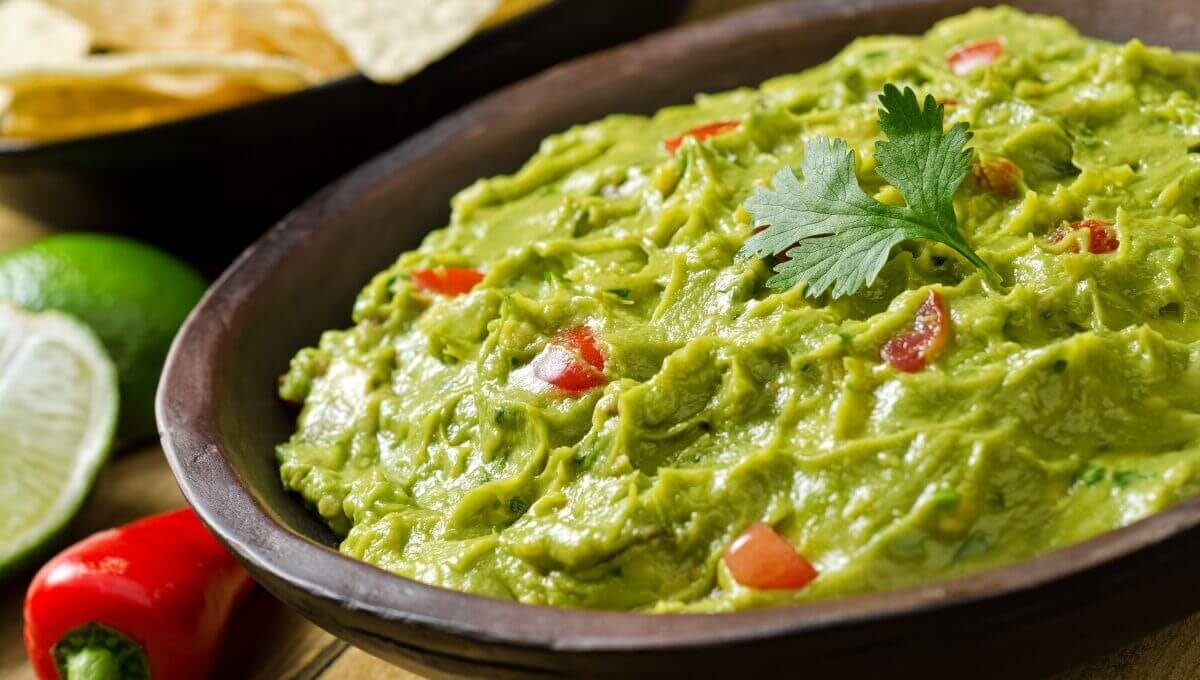 mélange guacamole 1 Mélange guacamole frais garni de coriandre, accompagné de piments rouges et citron vert