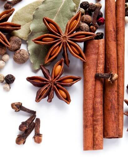 2 Composition d'épices aromatiques avec étoiles d'anis, bâtons de cannelle, feuille de laurier et clous de girofle sur fond blanc, ingrédients naturels pour le mélange 4 épices