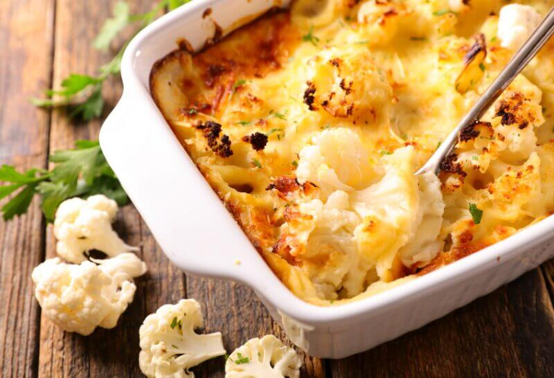 Gratin de Chou-fleur au Mélange Colombo 5 Plat de gratin de chou-fleur au mélange Colombo, doré et bouillonnant, servi dans un plat à gratin blanc.