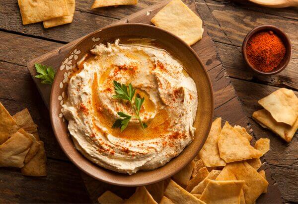Préparation d'houmous traditionnel avec pois chiches, tahini, huile d'olive et citron