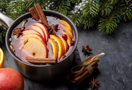 Vin Chaud Traditionnel aux épices et agrumes dans une casserole fumante, prêt à réchauffer les soirées d'hiver