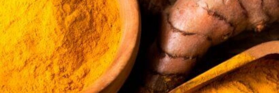 frische Kurkuma neben Kurkuma in Pulverform